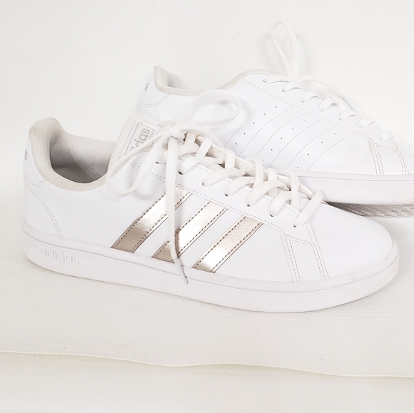 white adidas with gold stripes